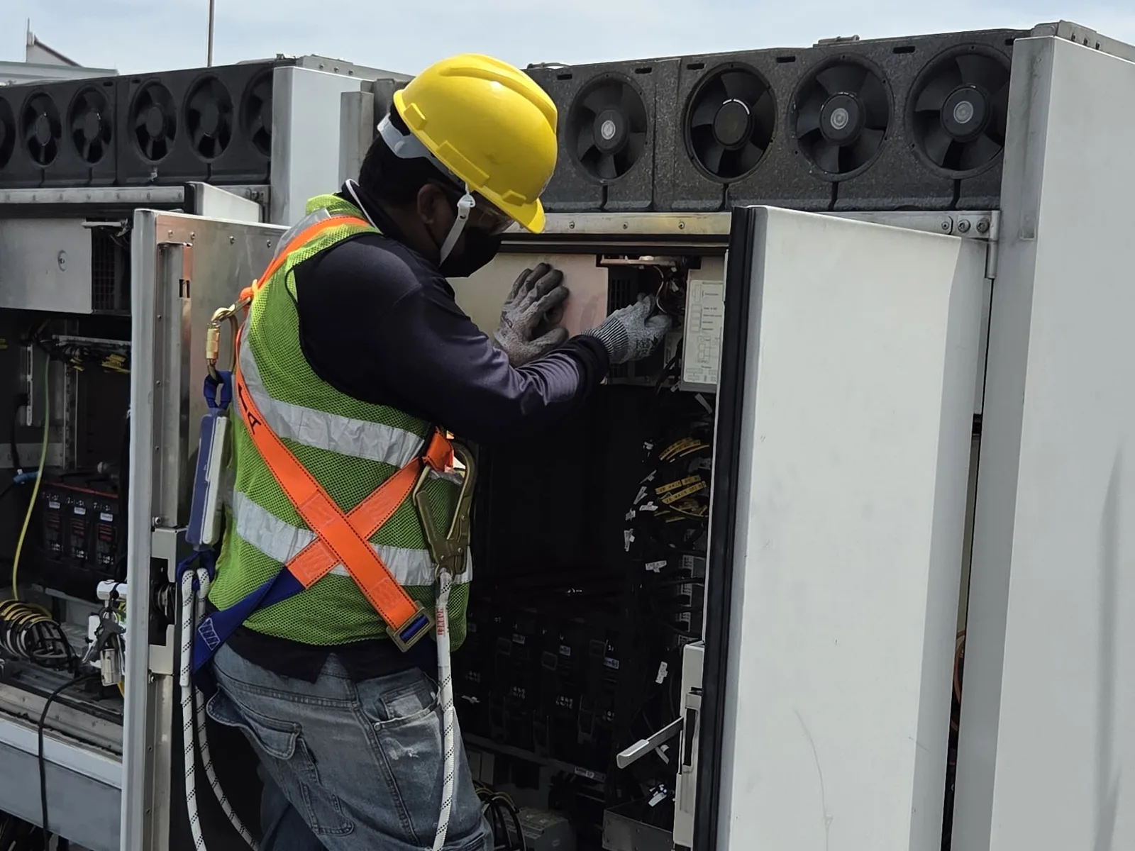 CCST technician servicing the interior of a rooftop climate-control unit cabinet