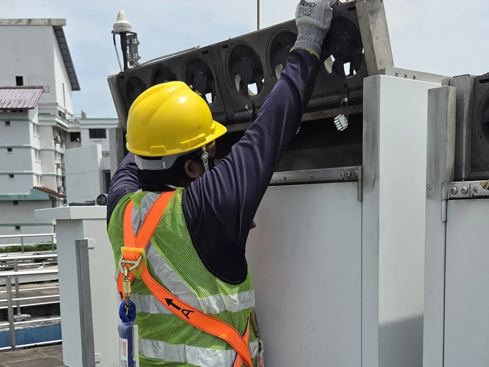 CCST technician removing a cooling-fan tray from a climate-control unit for cleaning