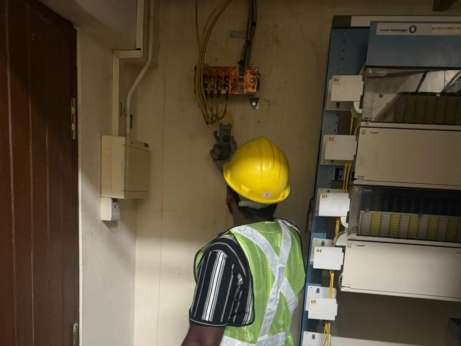 CCST technician measuring earthing continuity at an MDF room grounding bar