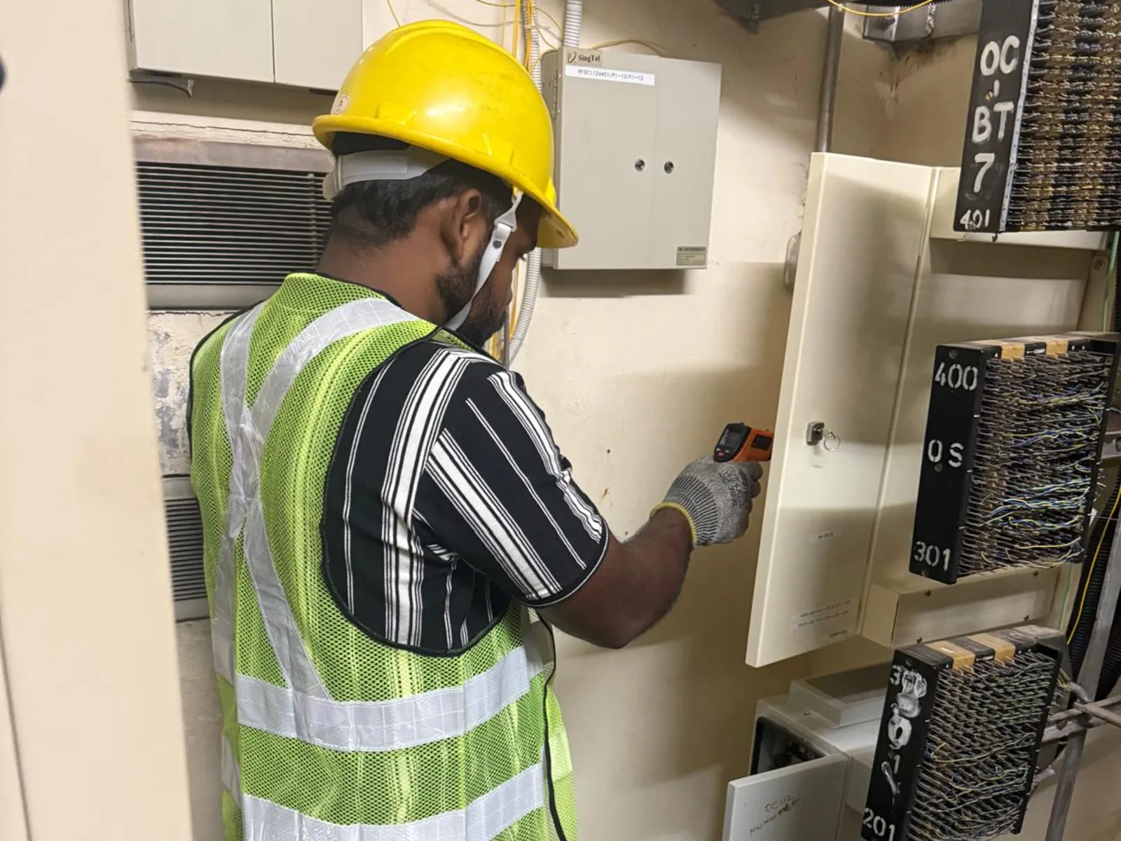 CCST technician taking an infrared temperature reading in an MDF room