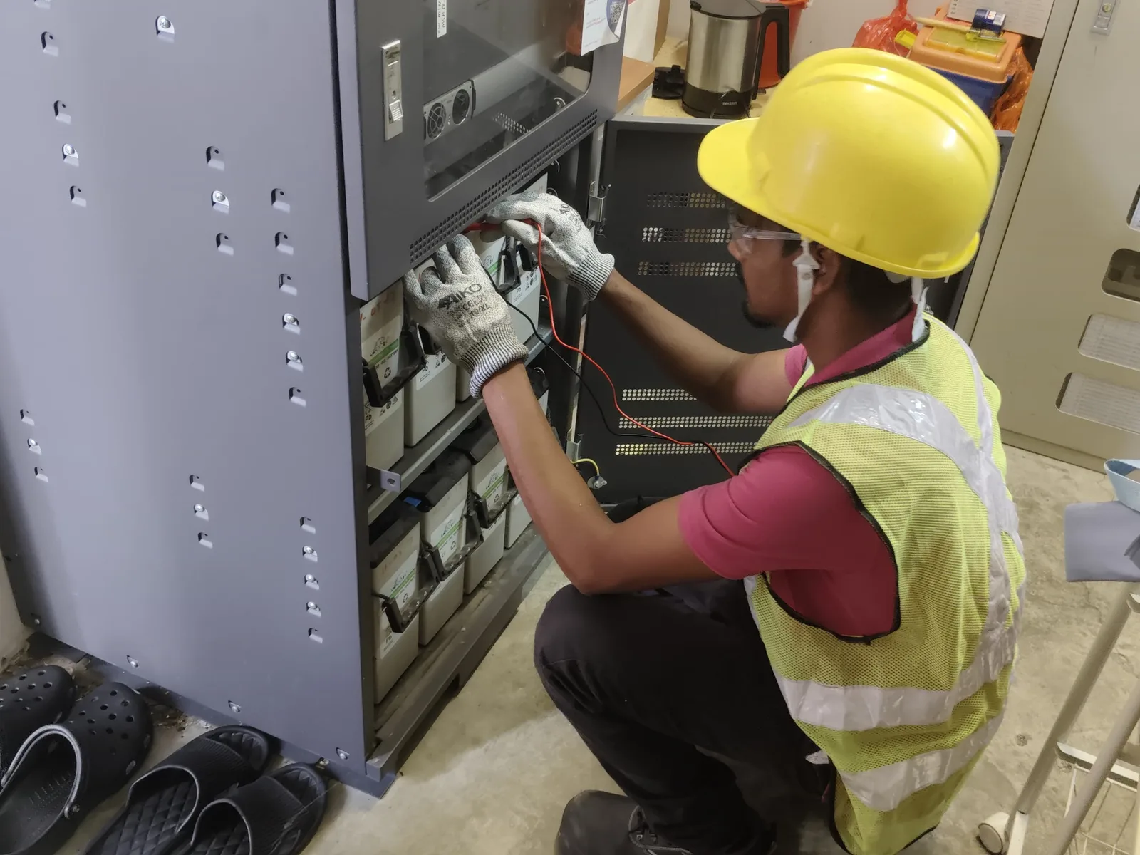 CCST technician performing a UPS battery health check with a multimeter